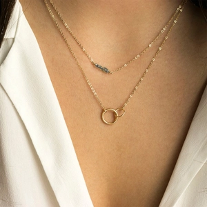 Collier double rang en acier inoxydable doré avec perles bleues et anneaux entrelacés