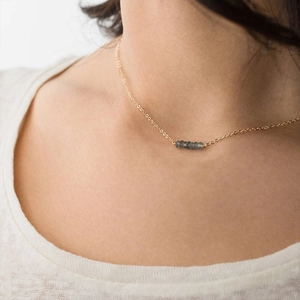 Collier minimaliste en perles de cristal avec chaîne dorée sur le mannequin