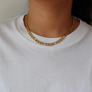 Close-up of gold Figaro chain necklace showing detailed links on a white background