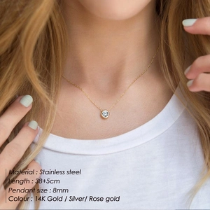Close-up of a minimalist 8mm zircon pendant on a stainless steel chain worn by a model