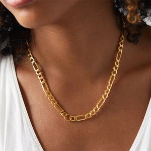 Close-up of golden Figaro chain necklace on neck showing elegant links and metallic polish