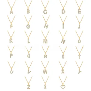 Golden stainless steel A-Z alphabet necklaces with pavé zircon crystals on white background