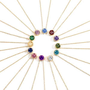 Macro shot of twelve round-cut birthstone pendants in gold bezel settings