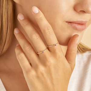 Details von minimalistischen Goldringen mit kleinen lila und roten Zirkonia-Steinen