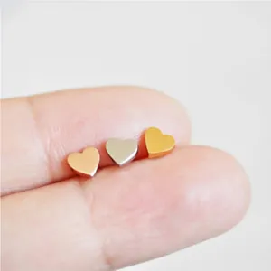Gros plan de trois paires de boucles d'oreilles cœur en finitions or, argent et rose