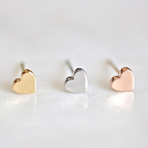 Détail des boucles d'oreilles cœur en finitions or, argent et or rose poli