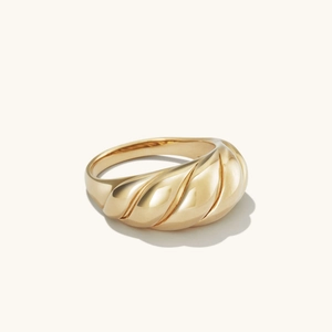 Macro detail of gold plated croissant dome ring featuring a twisted relief texture