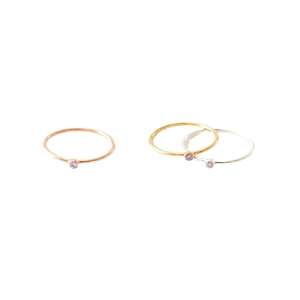 Three minimalist stainless steel rings in gold, rose gold and silver with purple stones