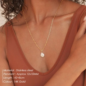Colgante de perla barroca en cadena de acero oro 14K lucido por una modelo real