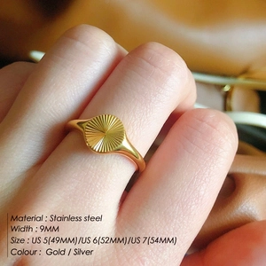 Detail shot of a 9mm stainless steel sunburst engraved ring on finger in gold and silver