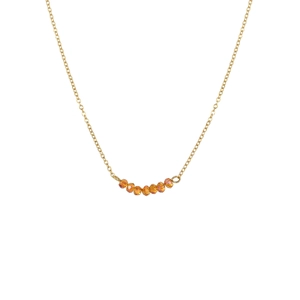 Détail du collier chaîne dorée minimaliste avec sept perles orange à facettes