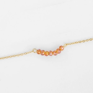 Vue détaillée du collier chaîne dorée avec sept perles ambrées facettées alignées