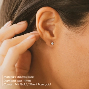 Macro de boucles d'oreilles clous de 4mm en acier inoxydable sur une oreille de femme
