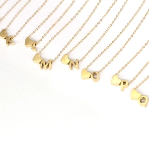 Collier avec pendentif cœur en acier titane doré et breloques de lettres élégantes