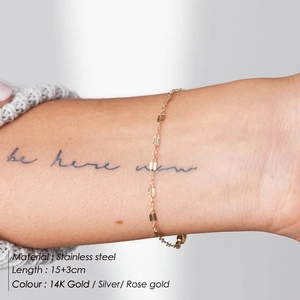 Detailed view of gold plated stainless steel lip link bracelet worn on a female wrist