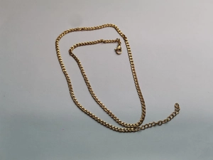 Detailansicht der goldenen Panzerkette mit Karabinerverschluss und Verlängerungskette