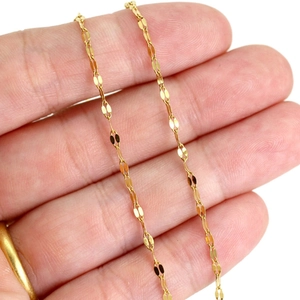Macro detail of a 24K gold-plated stainless steel lip chain with glossy petal links