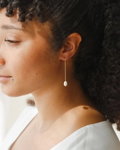 Elegant long gold chain drop earring featuring a lustrous white teardrop pearl on model