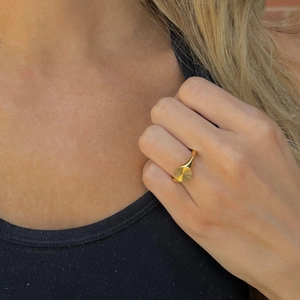 Detailed view of a gold signet ring featuring an engraved solar radiant sunburst texture