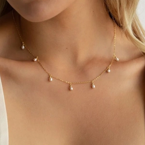 Minimalist gold stainless steel necklace with seven elegant oval white pearl droplets