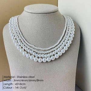 Multi-layer faux pearl necklace set in 14K gold plated stainless steel on a display stand