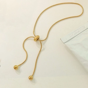 Adjustable gold stainless steel snake chain bracelet with sliding bead closure detail