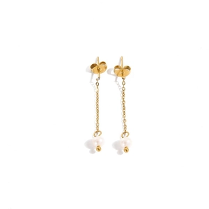 Detail showing elegant gold chain drop earrings with round white pearls and polished finish