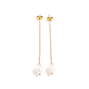 Detail of gold chain earrings with elegant white oval pearls on a minimalist background