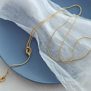 Minimalist gold knot snake chain necklace made of durable stainless steel shown at 45-degree angle