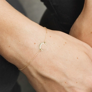 Detailed view of a gold crescent moon bracelet featuring a unique hammered metal texture