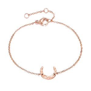 Detail of rose gold moon crescent bracelet with hammered metal texture and lobster clasp
