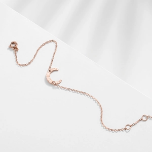 Detail of rose gold moon crescent bracelet with hammered texture finish and shadow