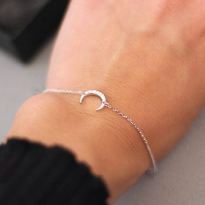 Detailed view of silver crescent moon bracelet with hammered texture on the wrist