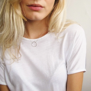 Silver stainless steel minimalist necklace with a hammered round pendant on model