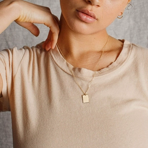 Collier doré en acier inoxydable avec pendentif rectangle sur mannequin, style minimaliste