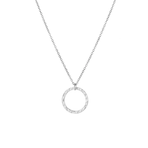 Détail macro du pendentif circulaire argenté martelé et de la fine chaîne en acier inoxydable