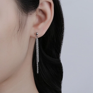 Close-up of silver long tassel drop earrings on model showing metal chain detail