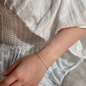 Gedetailleerd beeld van een fijne zilveren slangenketting armband om de pols