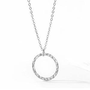Détail du collier en acier inoxydable argenté avec pendentif rond à texture martelée artisanale