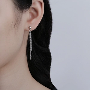 Close-up of silver long tassel earrings with stainless steel chains on model