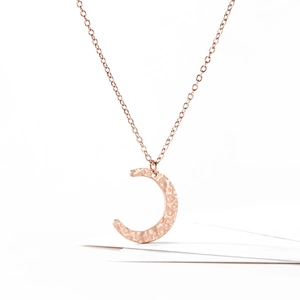 Close-up of rose gold crescent moon necklace with unique hammered texture and cable chain