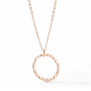 Détail du collier à pendentif rond en or rose avec une texture martelée élégante