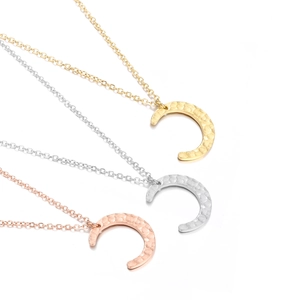 Three crescent moon necklaces in gold, silver and rose gold with hammered metal texture