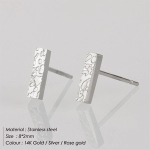 Macro shot of silver rectangle bar earrings with hammered texture on reflective surface