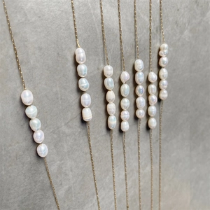 Macro detail of irregular baroque pearl necklaces with thin gold stainless steel chains
