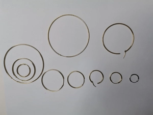 Vue à plat de créoles en acier inoxydable doré et argenté de différentes tailles en détail