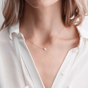 Elegant rose gold minimalist heart pendant necklace on female model wearing white shirt