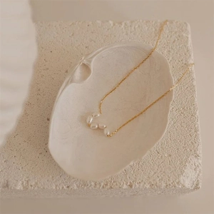 Detailed close-up of natural baroque pearls on a gold-plated stainless steel chain