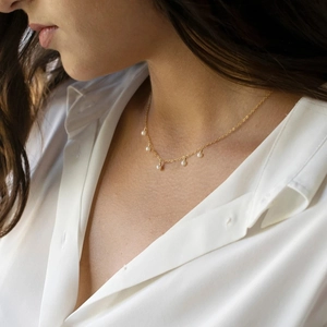 Elegant gold link necklace with five round white pearl pendants on female neck