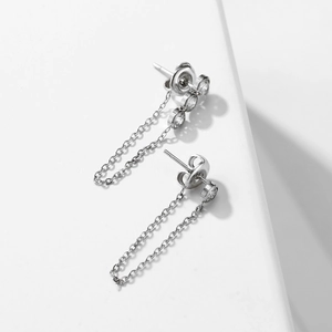Detailed macro view of polished stainless steel tassel earrings with sparkling zircon stones